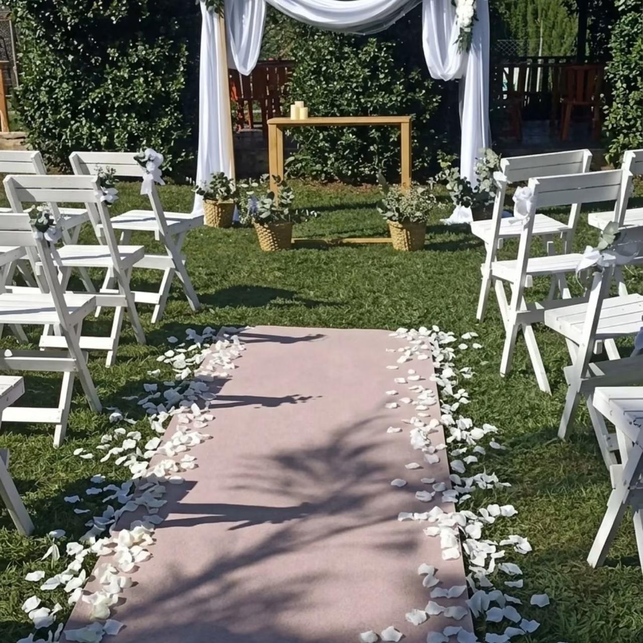 Ceremonia al aire libre con altar, telas blancas, flores y sillas decoradas