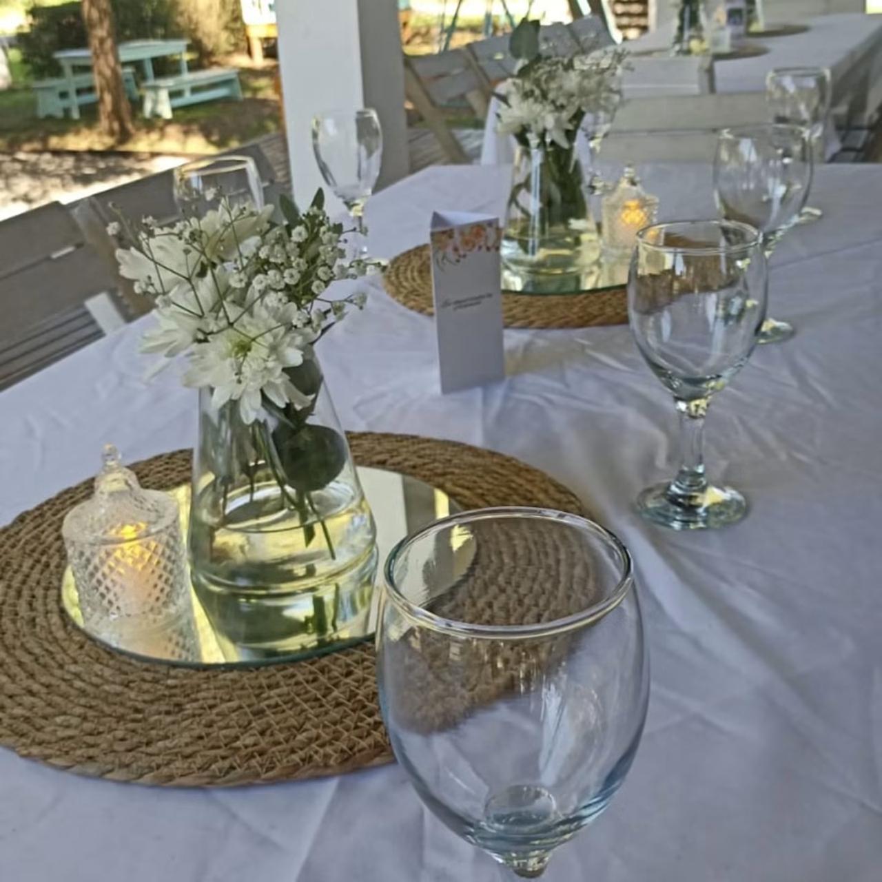 Mesa decorada con flores, velas y copas en la galería