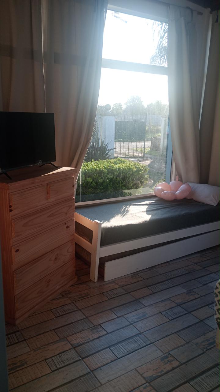 Cama marinera junto al ventanal, con cómoda y televisor